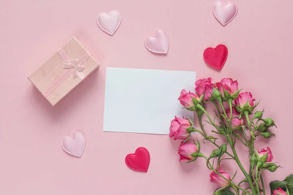 Bouquet di rose, confezione regalo e cuori con carta di carta bianca su un — Foto Stock