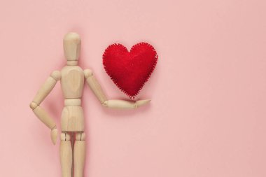 Klasik ahşap kukla kırmızı kalp Sevgililer günü için bir pi üzerinde tutar