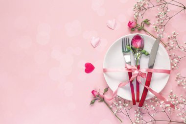 Festival tablo ayarını çatal bıçak takımı, gül, küçük beyaz çiçekler ile bir