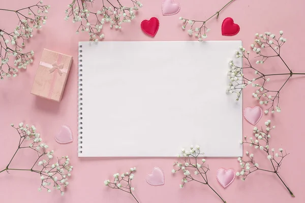 Album d'arte, fiori bianchi e confezione regalo su sfondo rosa. Copia s — Foto Stock