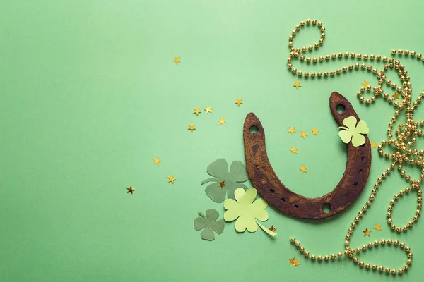 Green background with rusty horseshoe and paper clover leaves. S — Stock Photo, Image