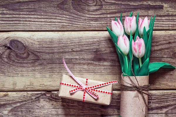 Sfondo con bouquet di tulipani rosa e confezione regalo in marrone — Foto Stock