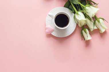 Kahve fincanı, beyaz gül çiçek ve kalp pembe bir arka plan üzerinde. Sayfanın Üstü