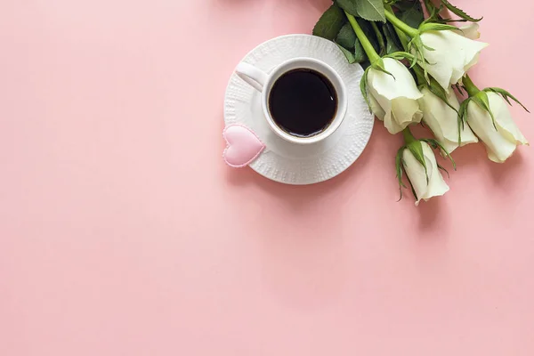 Kaffekopp, vita ros blommor och hjärta på rosa bakgrund. Topp — Stockfoto