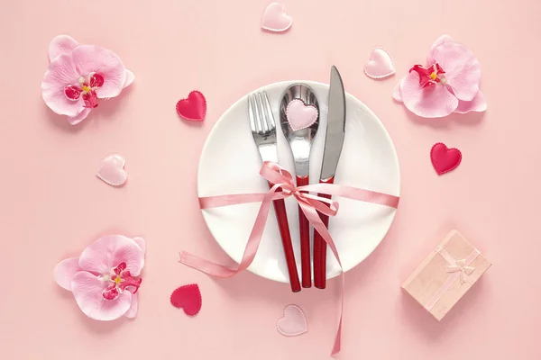 Festlig dukning med bestick, orkidé, presentförpackning och hjärtan — Stockfoto