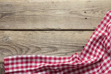 Eski bir ahşap masa üzerinde kırmızı kareli peçete. Metin için yer.