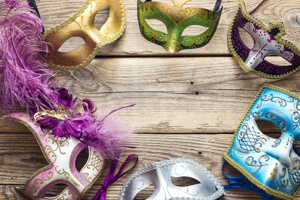 Slavnostní pozadí karnevalu s barevnými maskami na staré dřevěné — Stock fotografie