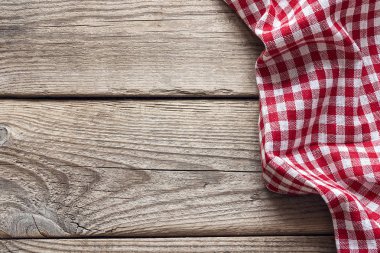 Eski bir ahşap masa üzerinde kırmızı kareli peçete. Metin için yer.