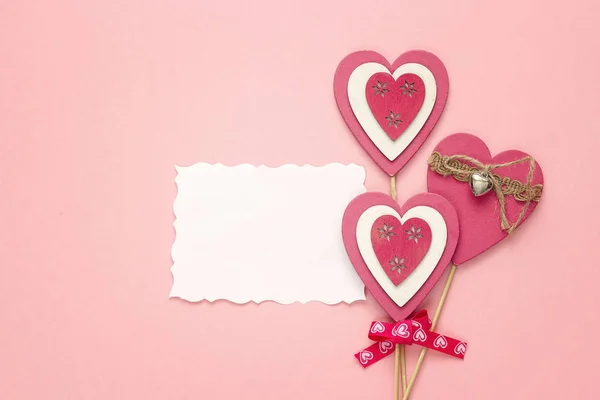 Tarjeta de papel vacía con corazones decorativos sobre un fondo rosa . —  Fotos de Stock