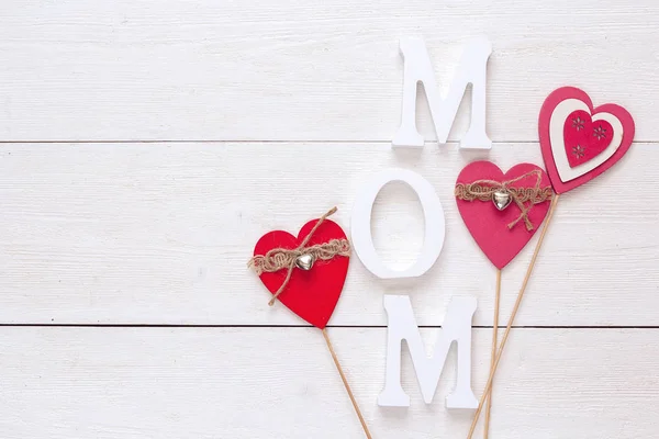 Mensagem de dia de mães com corações decorativos em um bac de madeira branco — Fotografia de Stock