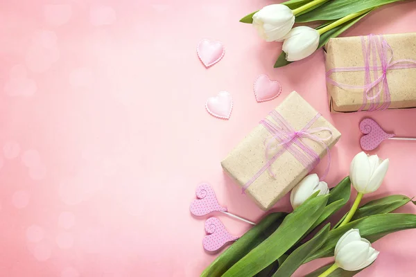 Tulipani bianchi, cuori e scatole regalo su sfondo rosa. Felice mo — Foto Stock
