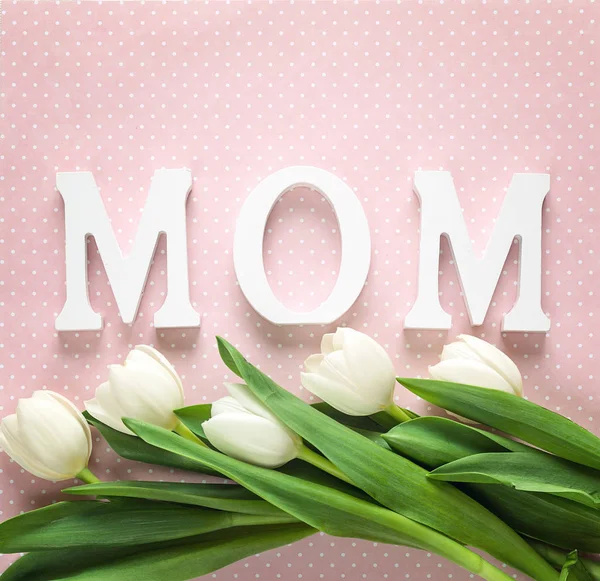 Mensaje del día de las madres con tulipanes blancos sobre fondo rosa . — Foto de Stock