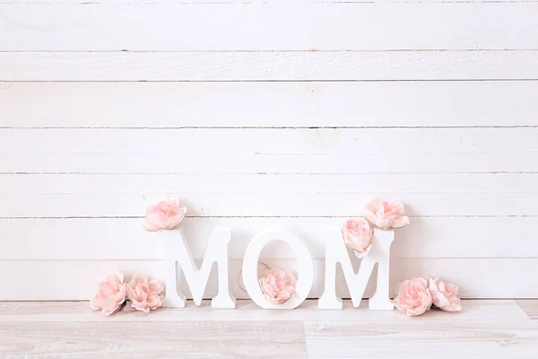 Mensagem do dia das mães com flores cor de rosa no fundo de madeira branco — Fotografia de Stock