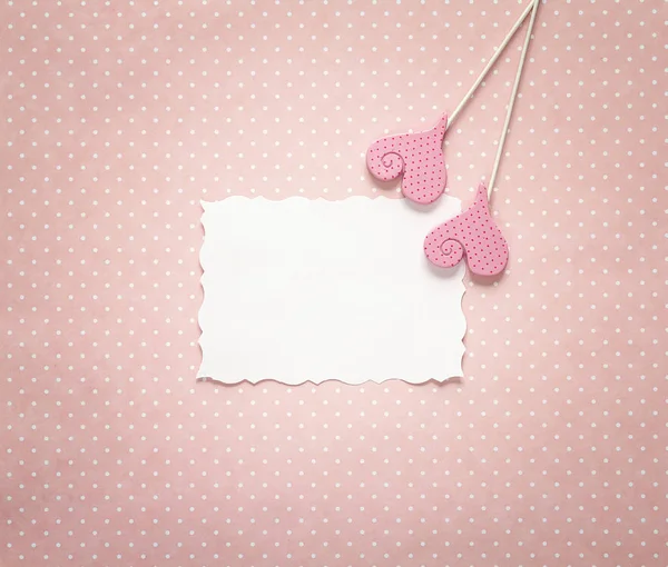 Tarjeta de papel en blanco con corazones decorativos en un bac de lunares rosa — Foto de Stock