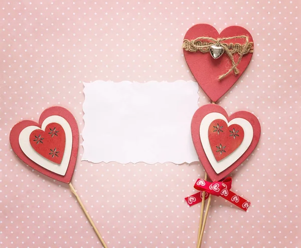 Tarjeta de papel vacía con corazones decorativos sobre un fondo rosa . —  Fotos de Stock