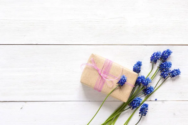 Caja de regalo con flores de muscari azul sobre fondo de madera blanca. P —  Fotos de Stock