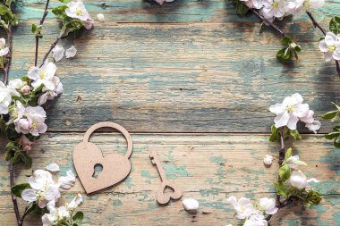 Elma çiçeği ile dekoratif kalp kilit ve anahtar üstünde ahşap backg