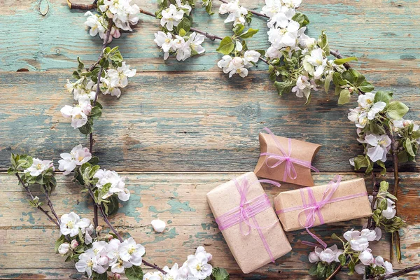 Apple blossom en geschenk dozen op oude houten achtergrond. Kopie vriendelij — Stockfoto