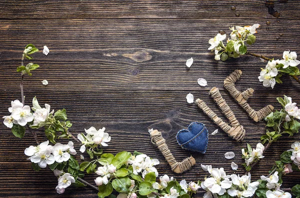 Flor de maçã com letras de papelão amor no fundo de madeira . — Fotografia de Stock