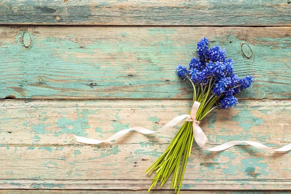 Букет з синіх квітів мускарі на старому пофарбованому тлі. Планка — стокове фото