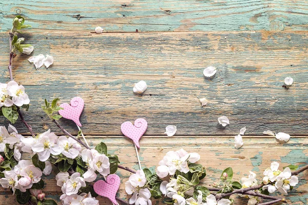 Ramas florecientes de manzanos con corazones decorativos en madera — Foto de Stock