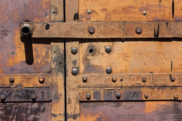 리벳으로 오래 된 녹슨 철 문의 조각. — 스톡 사진