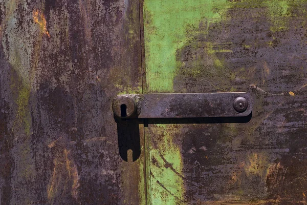 Rusty metal gate background with old layers of green paint.