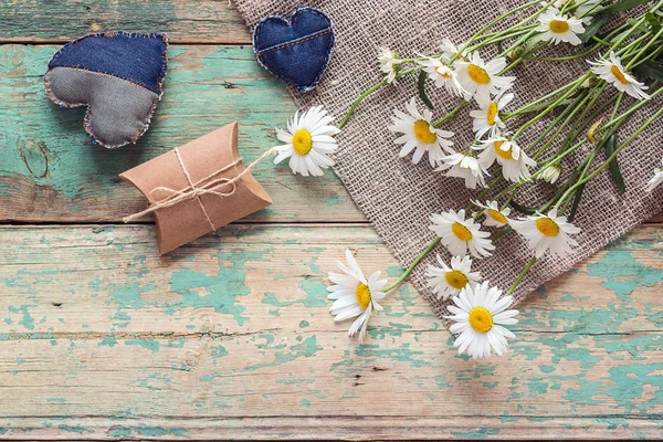 Букет ромашок з подарунковою коробкою і джинсовими серцями на старому дерев'яному — стокове фото