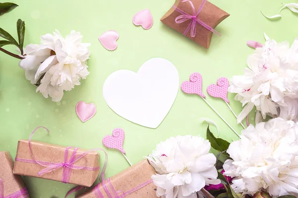 Witte pioenrozen met lege hart-kaart, geschenkdozen en decoratieve h — Stockfoto