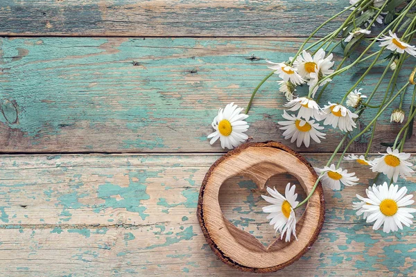 Ramillete de margaritas con corazón de madera sobre fondo de madera viejo. P — Foto de Stock