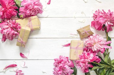 Pembe peonies hediye kutuları üzerinde beyaz tahta arka plan ile. Yer