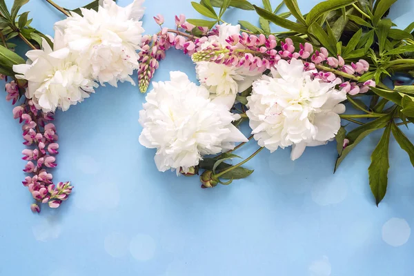 Beyaz peonies ve pembe kurt çiçekler ile mavi arka plan.