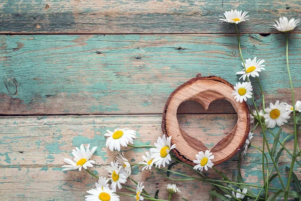 古い木製の背景の木の心とデイジーの花束。P — ストック写真