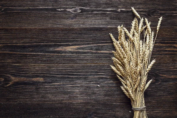 Sfondo con spighe di grano sulle tavole di legno scuro . — Foto Stock