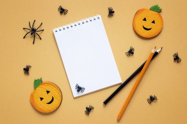 Turuncu backdro üzerinde Halloween süslemeleri ile boş açık not etmek