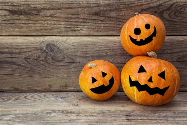 Üç turuncu bir eski ahşap Komiteler bir arka plan üzerinde kabak.