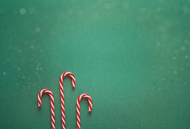 Yeşil Noel arka plan kırmızı şekerler ile. Kopya alanı için 