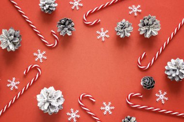 Baston şekerler ve çam kozalakları kırmızı Noel arka plan. Kopya 