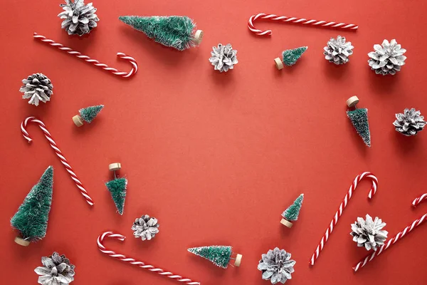 Firs, şekerler ve çam kozalakları kırmızı Noel arka plan. 