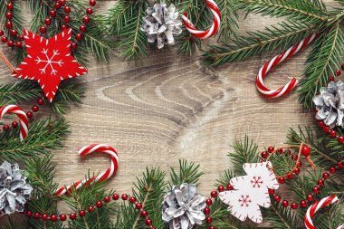 Çerçeve üzerinde ahşap masa süslemeleri ve Noel şekerler köknar dalı. Metin için yer