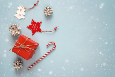 Noel süslemeleri mavi zemin üzerine kırmızı hediye kutusu. Polis