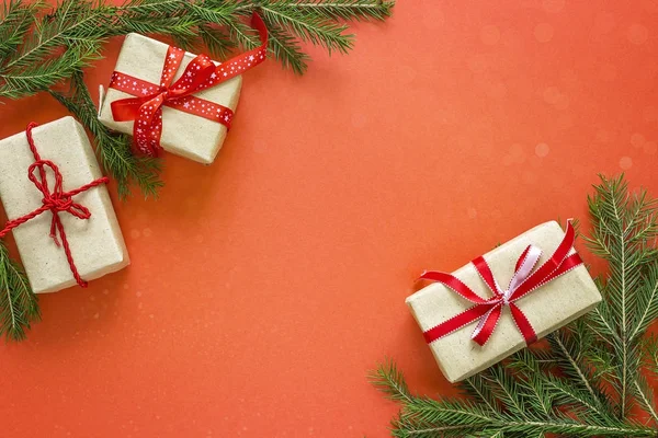 Christmas gift boxes and fir branches on red background. Space f — Stock Photo, Image