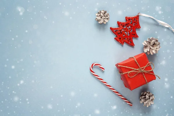 Κόκκινο δώρο κουτί με τις διακοσμήσεις Χριστουγέννων σε μπλε φόντο. Μπάτσος — Φωτογραφία Αρχείου