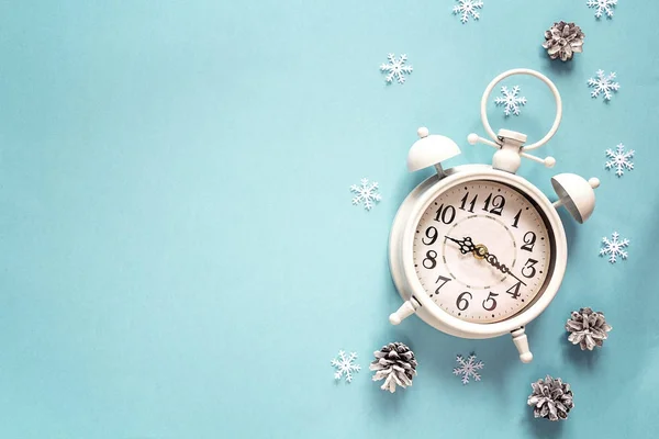 블루 backgro에 소나무 콘 및 복사 공간 겨울 알람 시계 — 스톡 사진