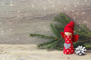 Köknar dallar ahşap arka plan üzerinde kırmızı Noel meleği. Kopya