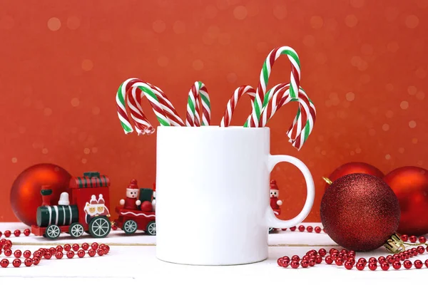 Hrnek na kávu bílý s vánoční výzdobou na červeném pozadí. — Stock fotografie