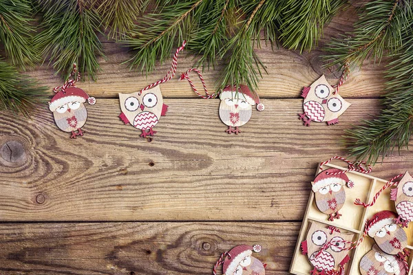 Christmas background with funny owls and pine branches on old wo
