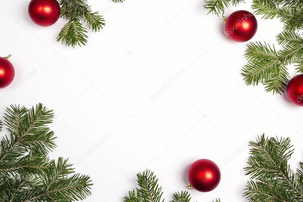 Green Christmas fir tree branches with red balls and copy space.