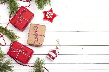 Hediye kutuları ve Beyaz ahşap zemin üzerinde Noel süsleri.