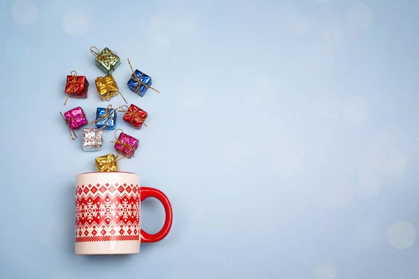 Christmas mug with gift boxes coming out of it  on blue backgrou — Stock Photo, Image